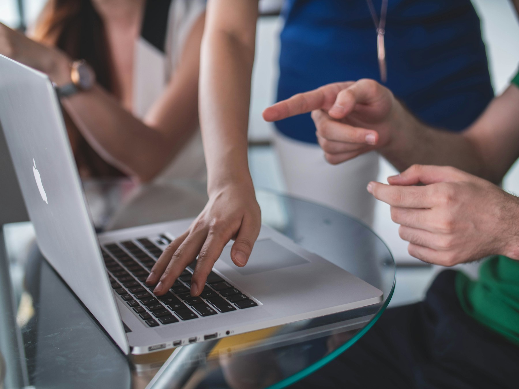 Colleagues collaborating around a laptop